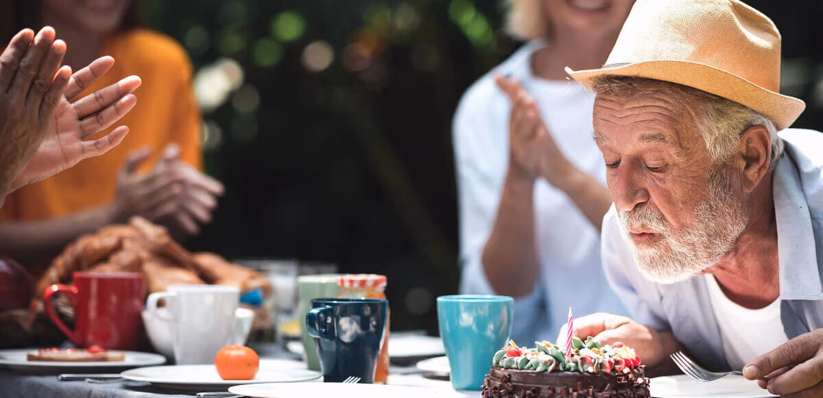 Senior man celebrating his birthday in a backyard garden setting